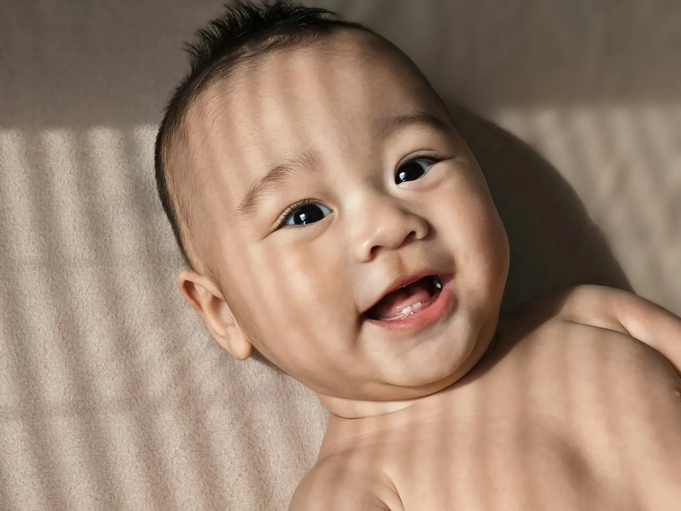 Bayi tersenyum berbaring di kasur